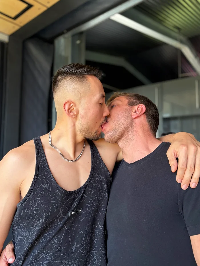 Adam Chen holding Troy Saga close in a passionate bedroom moment
